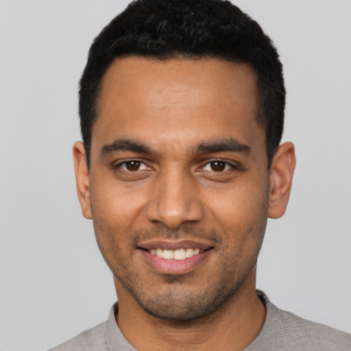 Joyful latino young-adult male with short  black hair and brown eyes