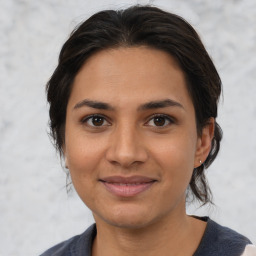 Joyful latino young-adult female with medium  brown hair and brown eyes