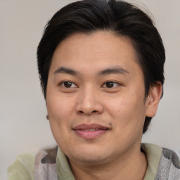 Joyful asian young-adult male with medium  brown hair and brown eyes