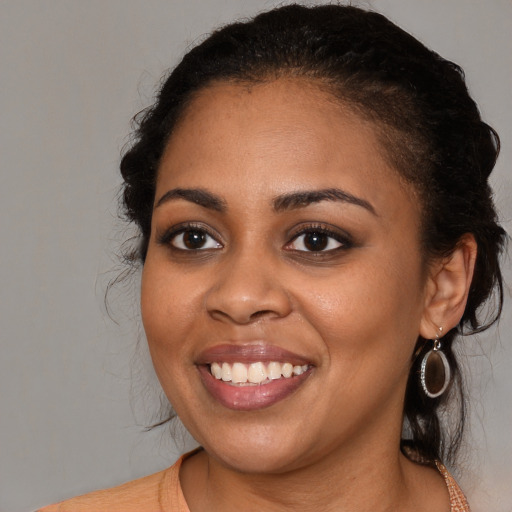 Joyful black young-adult female with long  brown hair and brown eyes