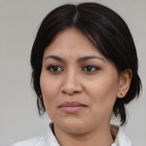 Joyful latino adult female with medium  brown hair and brown eyes