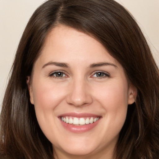 Joyful white young-adult female with long  brown hair and brown eyes