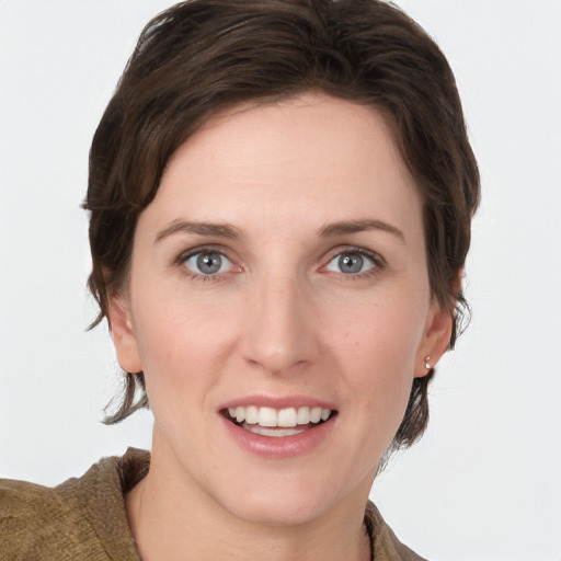 Joyful white young-adult female with medium  brown hair and grey eyes