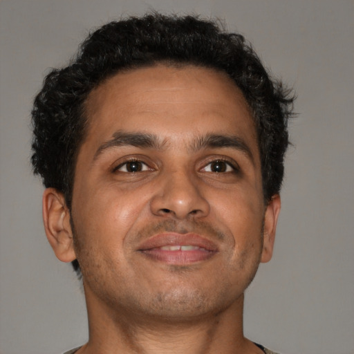 Joyful latino adult male with short  brown hair and brown eyes