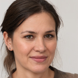 Joyful white adult female with medium  brown hair and brown eyes