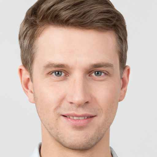 Joyful white young-adult male with short  brown hair and grey eyes