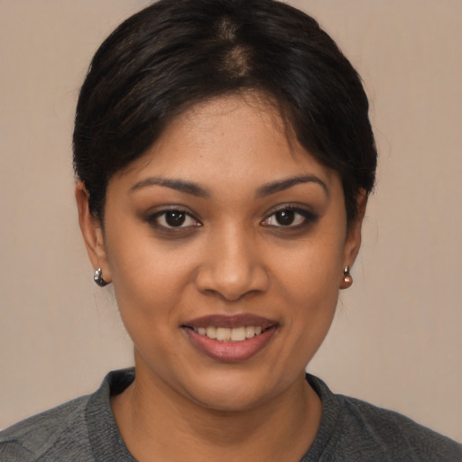 Joyful latino young-adult female with short  black hair and brown eyes