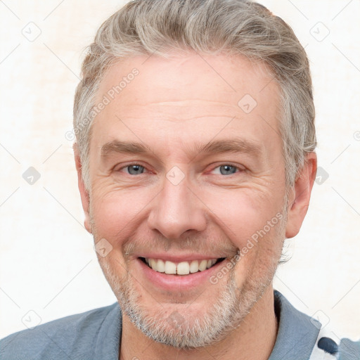 Joyful white adult male with short  brown hair and grey eyes