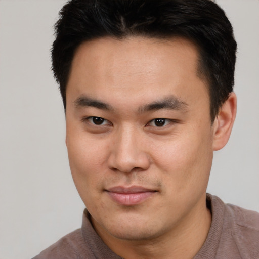 Joyful asian young-adult male with short  black hair and brown eyes