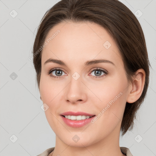 Joyful white young-adult female with medium  brown hair and grey eyes