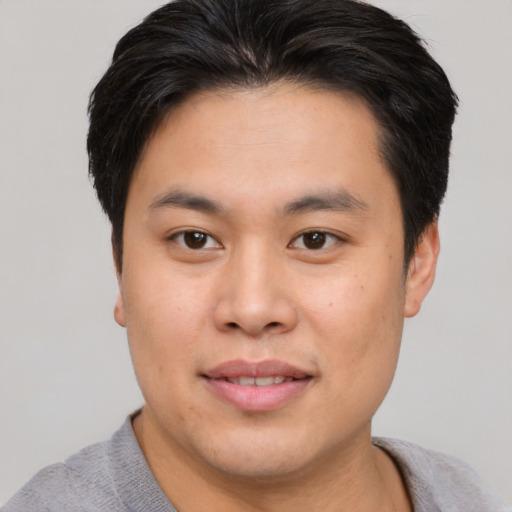 Joyful asian young-adult male with short  brown hair and brown eyes