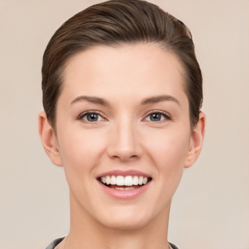 Joyful white young-adult female with short  brown hair and grey eyes