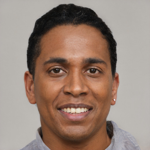 Joyful latino young-adult male with short  black hair and brown eyes