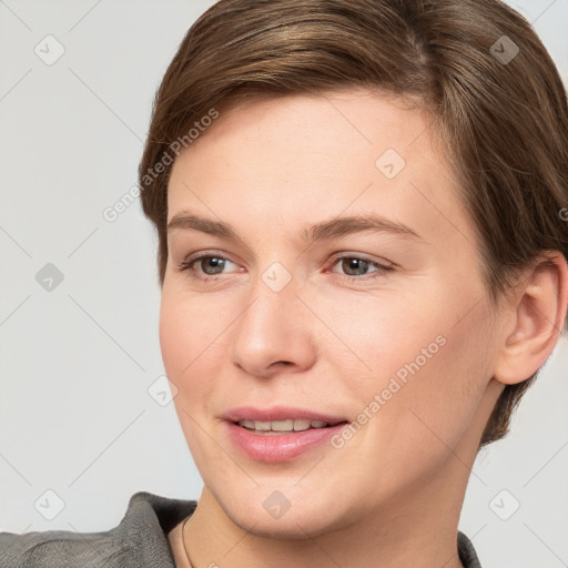 Joyful white young-adult female with short  brown hair and grey eyes