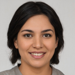 Joyful latino young-adult female with medium  brown hair and brown eyes