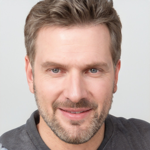 Joyful white adult male with short  brown hair and grey eyes