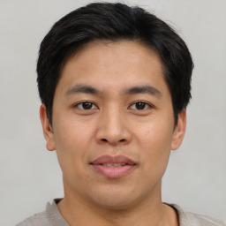 Joyful asian young-adult male with short  brown hair and brown eyes