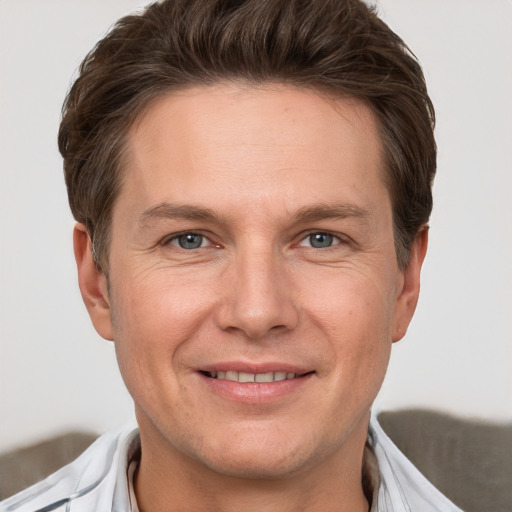 Joyful white adult male with short  brown hair and grey eyes