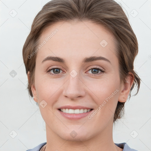 Joyful white young-adult female with medium  brown hair and grey eyes