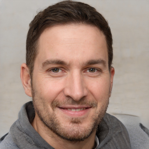 Joyful white adult male with short  brown hair and grey eyes