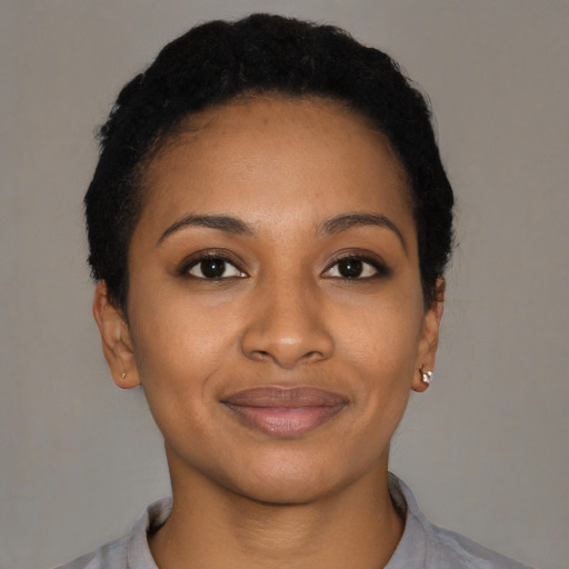 Joyful black young-adult female with short  black hair and brown eyes