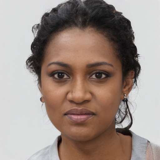 Joyful black young-adult female with short  black hair and brown eyes