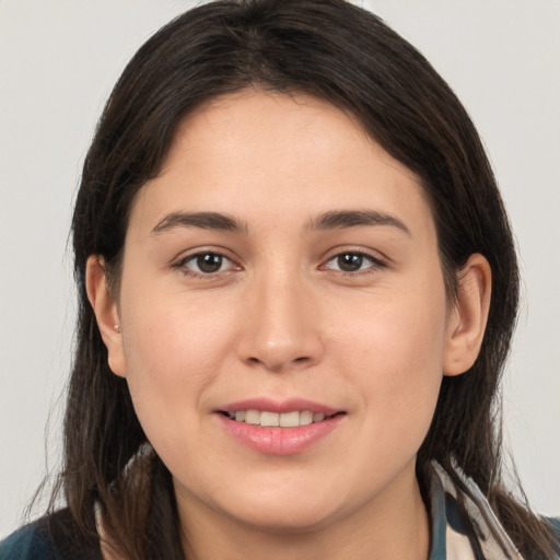 Joyful white young-adult female with long  brown hair and brown eyes