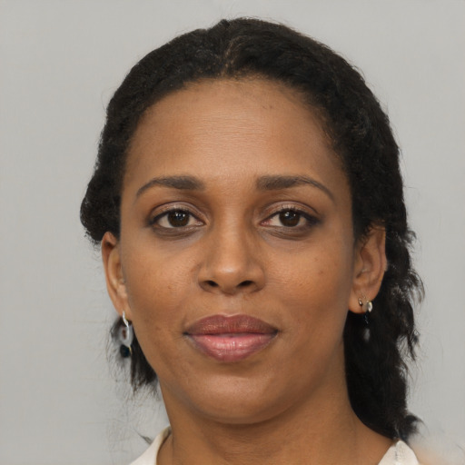Joyful black adult female with medium  brown hair and brown eyes