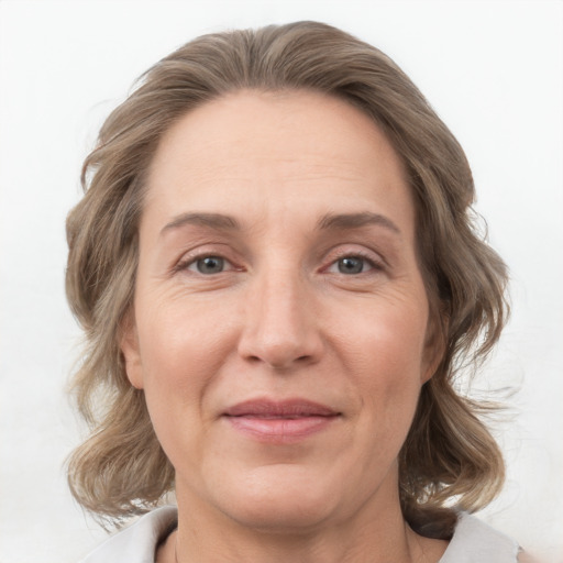 Joyful white adult female with medium  brown hair and grey eyes