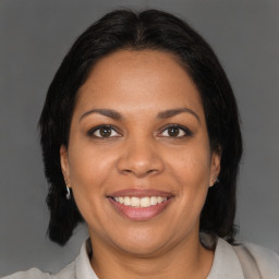 Joyful black adult female with medium  brown hair and brown eyes