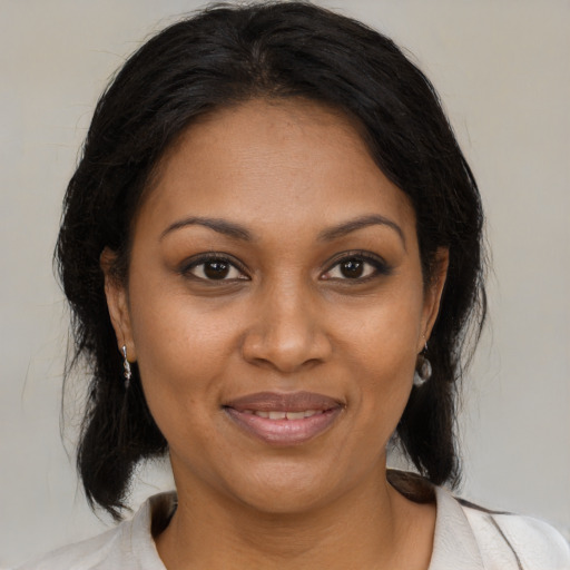 Joyful black adult female with medium  brown hair and brown eyes