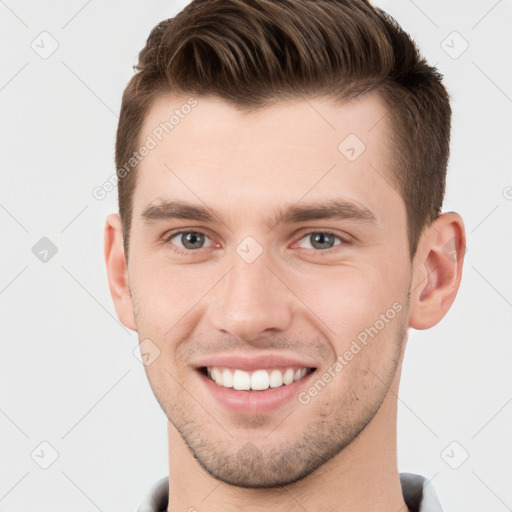 Joyful white young-adult male with short  brown hair and grey eyes