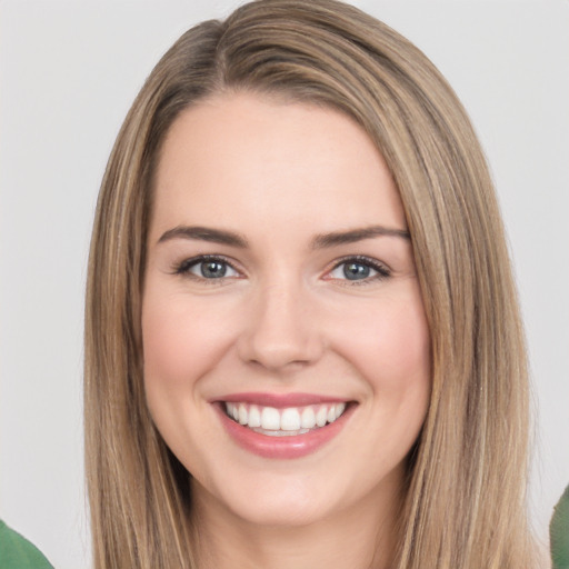 Joyful white young-adult female with long  brown hair and green eyes