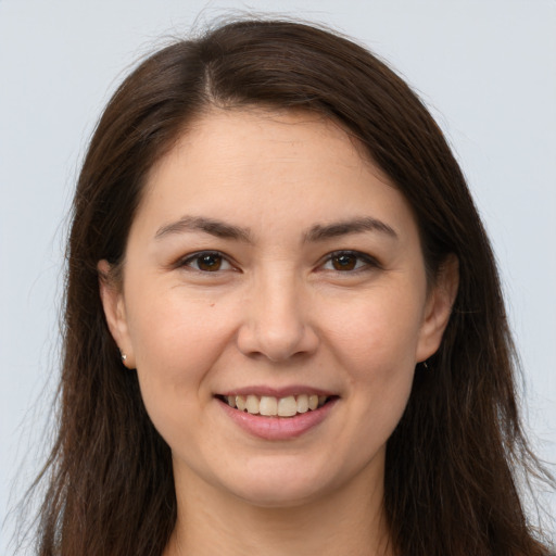 Joyful white young-adult female with long  brown hair and brown eyes
