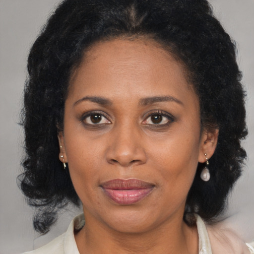Joyful black adult female with medium  brown hair and brown eyes