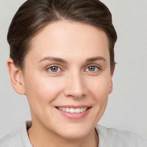 Joyful white young-adult female with short  brown hair and grey eyes