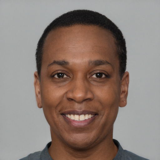 Joyful black adult male with short  black hair and brown eyes