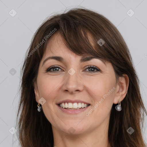 Joyful white adult female with long  brown hair and grey eyes