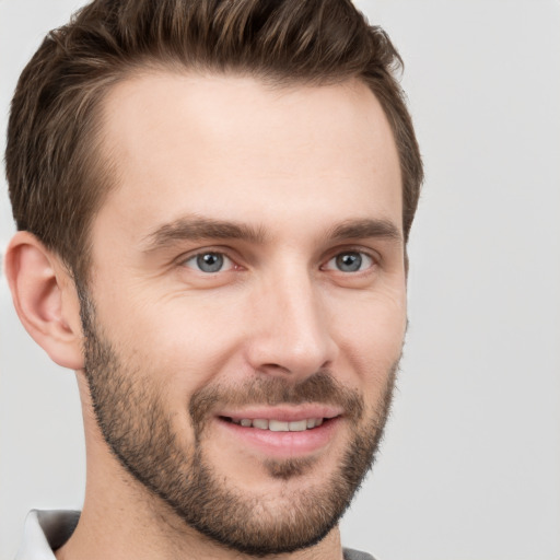 Joyful white young-adult male with short  brown hair and grey eyes