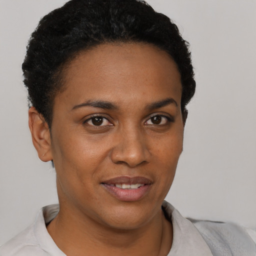 Joyful black young-adult female with short  black hair and brown eyes