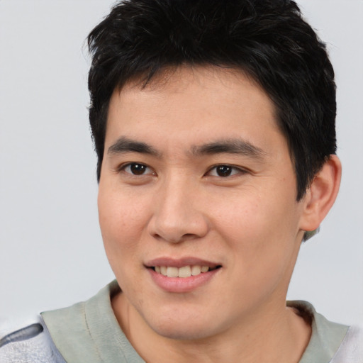 Joyful asian young-adult male with short  brown hair and brown eyes