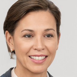 Joyful white adult female with medium  brown hair and brown eyes