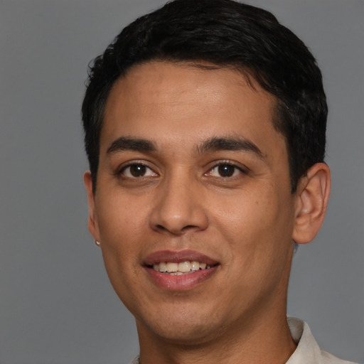 Joyful white young-adult male with short  black hair and brown eyes