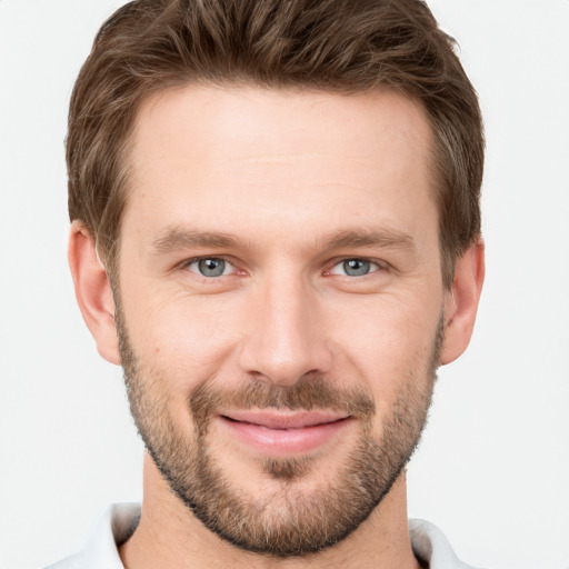 Joyful white young-adult male with short  brown hair and grey eyes