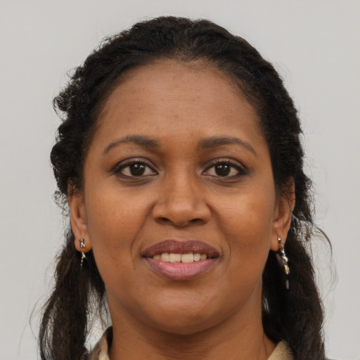 Joyful black young-adult female with long  brown hair and brown eyes