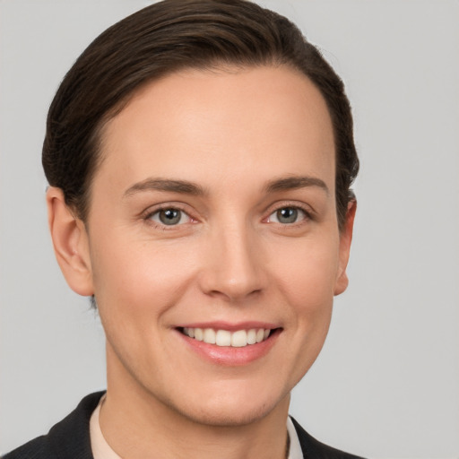 Joyful white young-adult female with short  brown hair and grey eyes