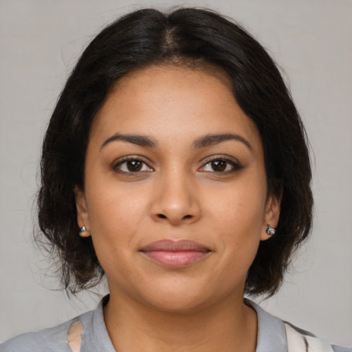 Joyful latino young-adult female with medium  brown hair and brown eyes