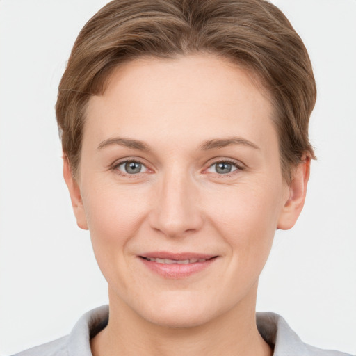 Joyful white young-adult female with short  brown hair and grey eyes