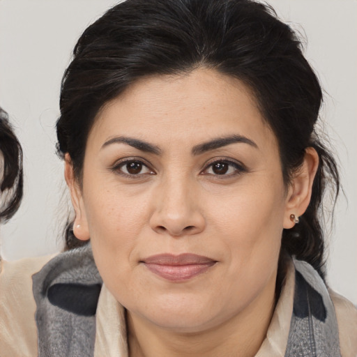 Joyful latino adult female with medium  brown hair and brown eyes