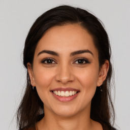 Joyful latino young-adult female with long  brown hair and brown eyes